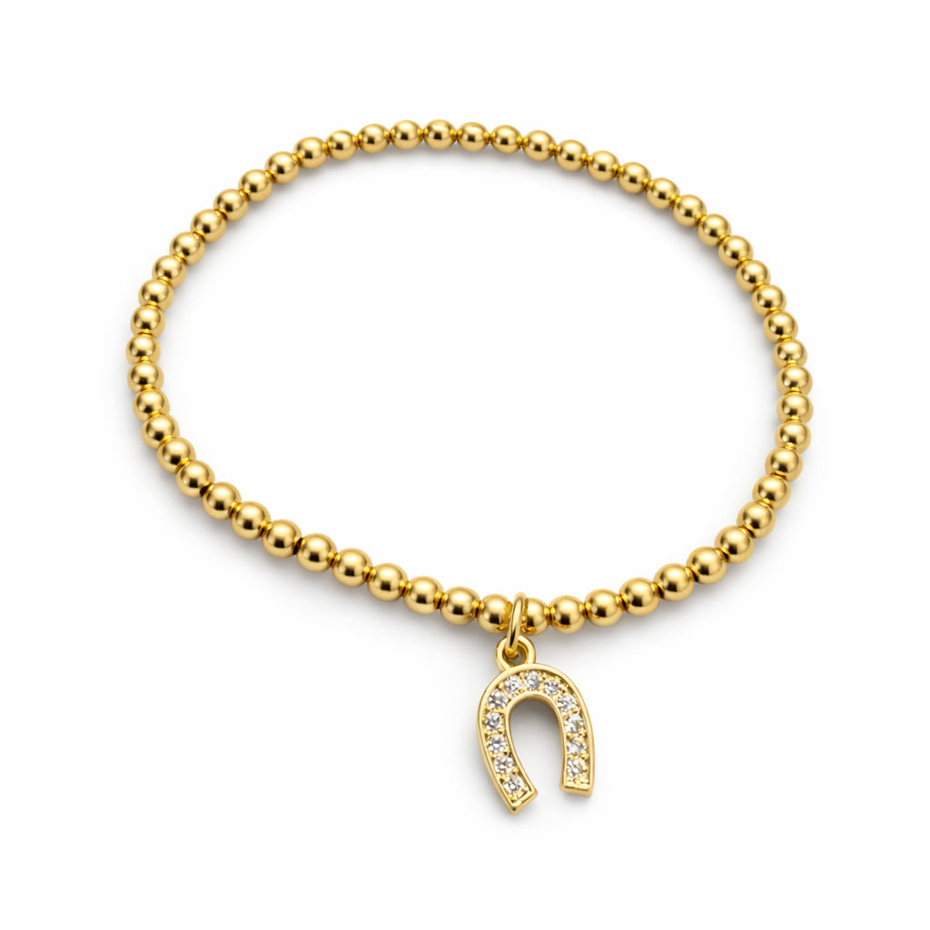 Gold beaded bracelet with a horseshoe charm on a white background