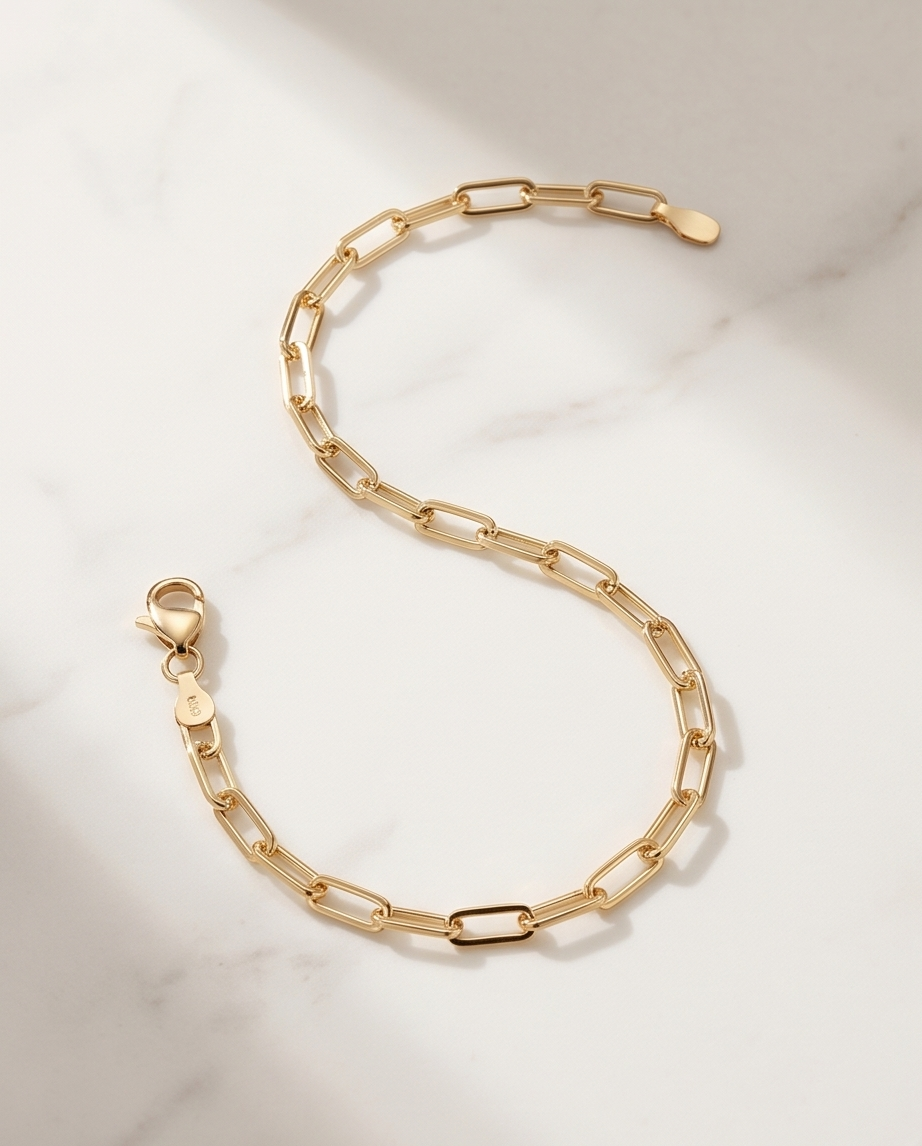 14k gold filled paperclip chain bracelet flat lay on marble with lobster clasp detail — Linked by Stacked by Jayneebell