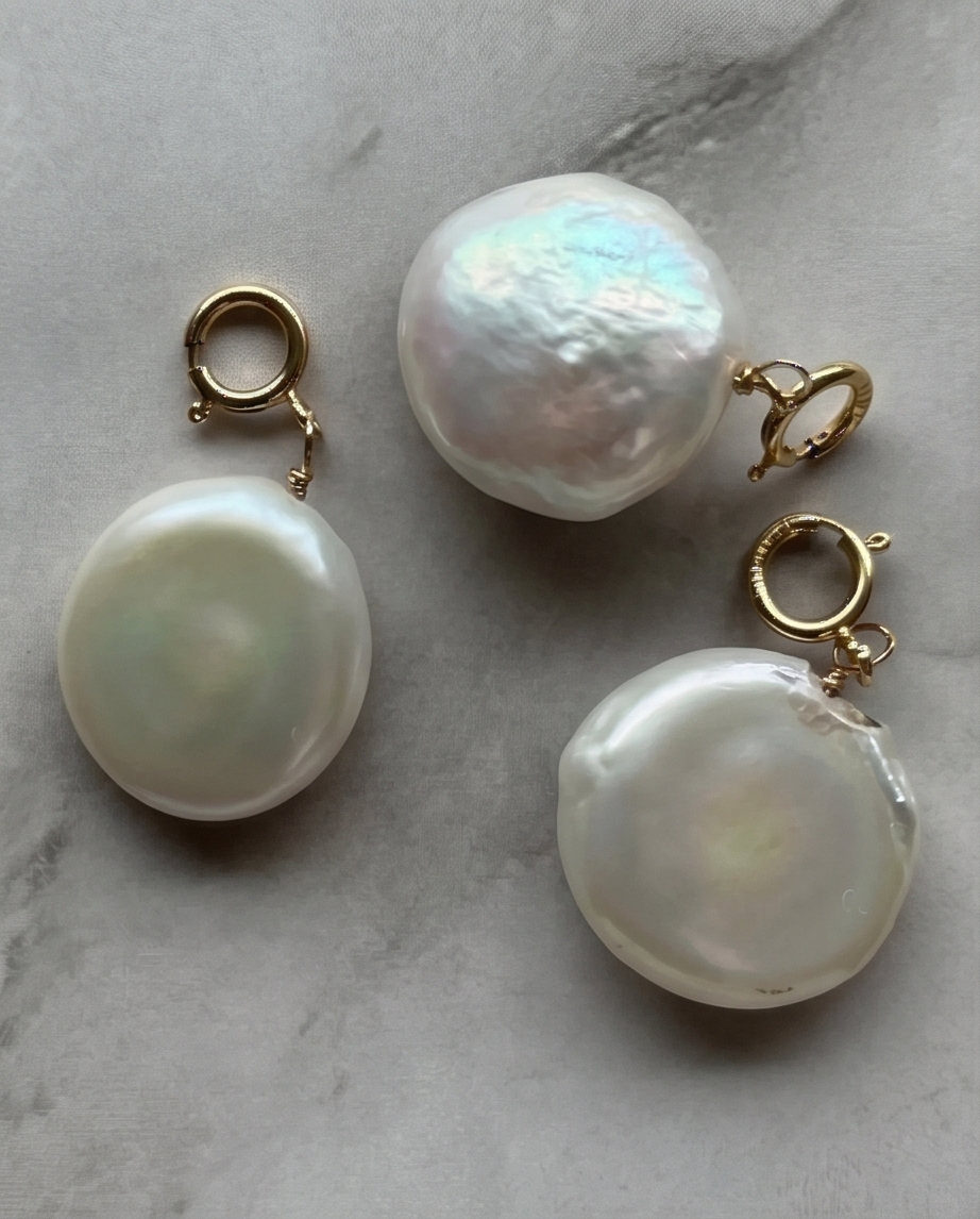 Three genuine freshwater coin pearl pendants with gold filled spring ring clasps on marble — Stacked by Jayneebell