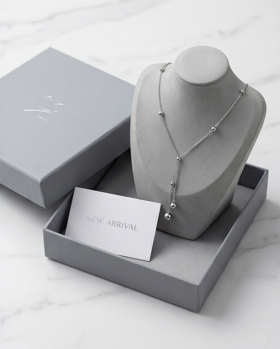 Silver necklace on a gray bust with a &