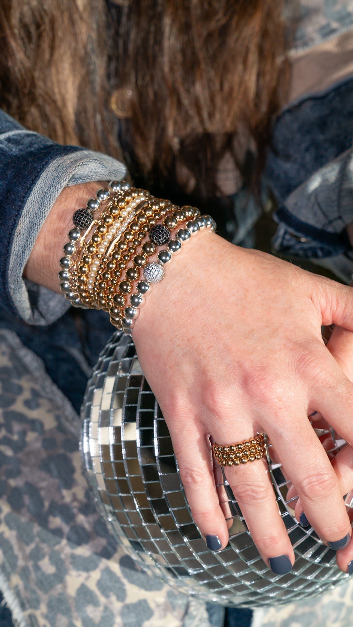 Gold plated beaded stretch bracelets styled in a layered stack