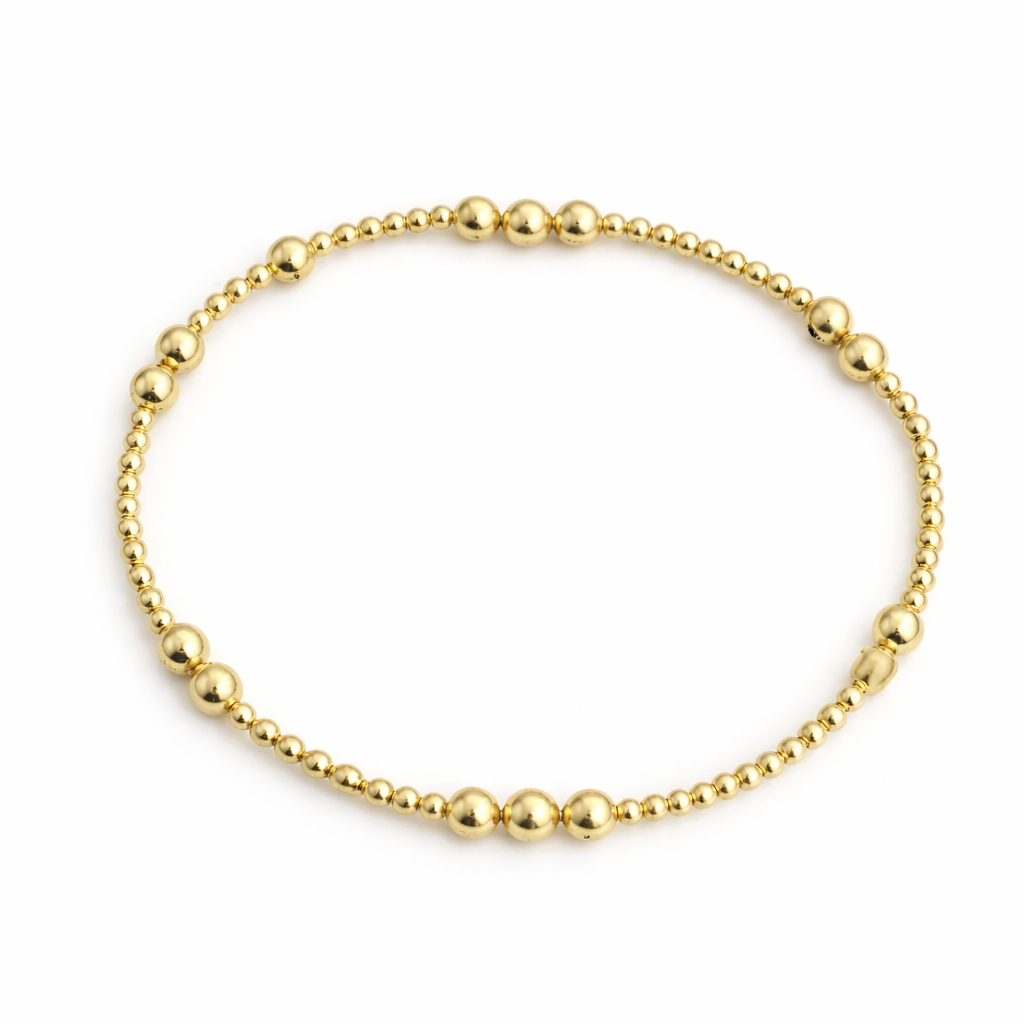 Gold beaded bracelet on a white background