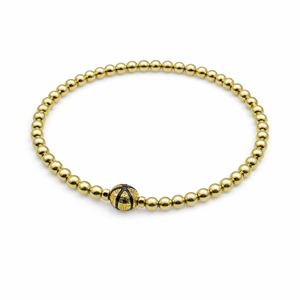 Gold beaded bracelet with a black and gold clasp on a white background