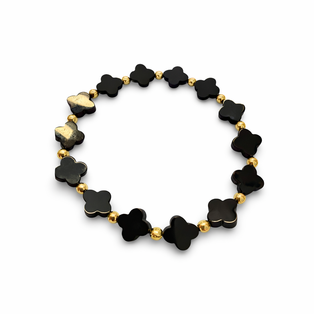 Black onyx clover-shaped beaded bracelet with gold accents on a white background