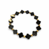 Black onyx clover-shaped beaded bracelet with gold accents on a white background