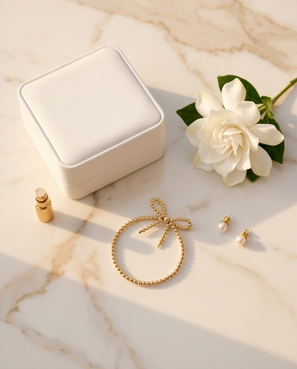 The Coquette gold bow bracelet styled with jewelry box gardenia and pearl earrings — Stacked by Jayneebell