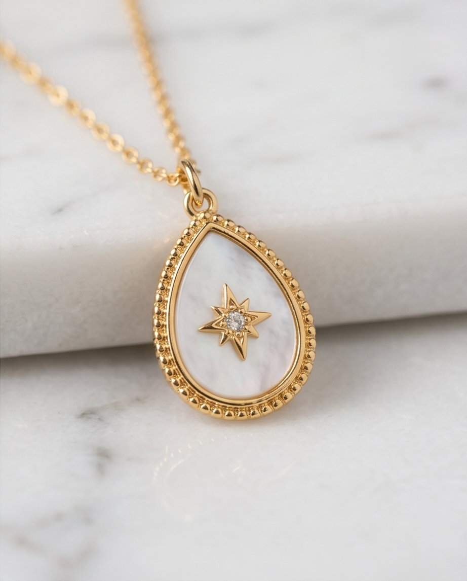 True North mother of pearl teardrop pendant on gold chain on marble, Stacked by Jayneebell