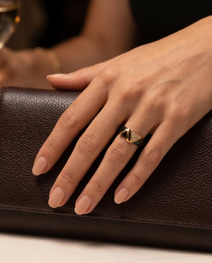 Model wearing Avant black ceramic gold geometric ring on hand with leather clutch, Stacked by Jayneebell