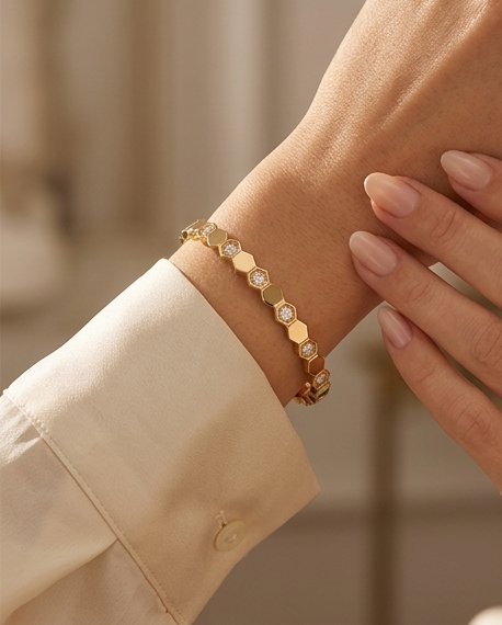 Model wearing The Hive Bangle gold honeycomb bangle bracelet on wrist, Stacked by Jayneebell