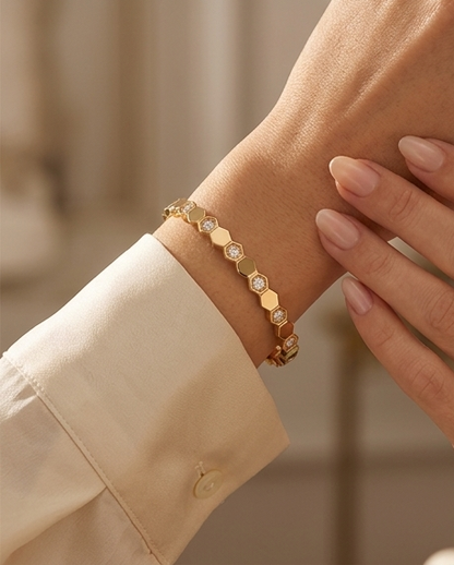 Model wearing The Hive Bangle gold honeycomb bangle bracelet on wrist, Stacked by Jayneebell