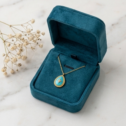 Gold necklace with a blue pendant in an open teal jewelry box on a marble surface.Close-up detail of True North turquoise inlay and pavé CZ north star with gold milgrain border, Stacked by Jayneebell