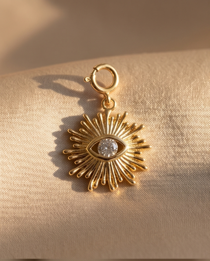 Gold filled evil eye sunburst convertible charm with cubic zirconia center stone on linen background — Stacked by Jayneebell