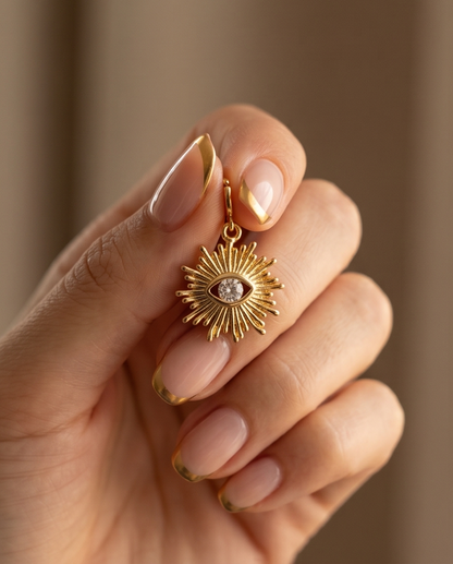 Hand holding gold filled evil eye sun charm with spring ring clasp — Stacked by Jayneebell