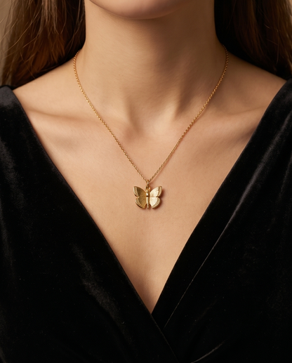 Gold butterfly necklace on a black background