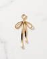 Gold filled open wire ribbon bow charm with long trailing tails and spring ring clasp on marble — Stacked by Jayneebell