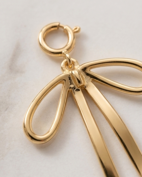  Close up of gold filled ribbon bow charm knot detail with spring ring clasp on marble — Stacked by Jayneebell
