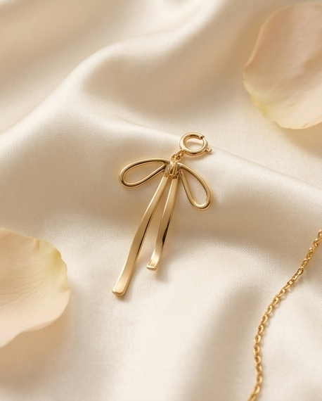 Gold filled ribbon bow convertible charm on silk fabric beside gold chain — Stacked by Jayneebell