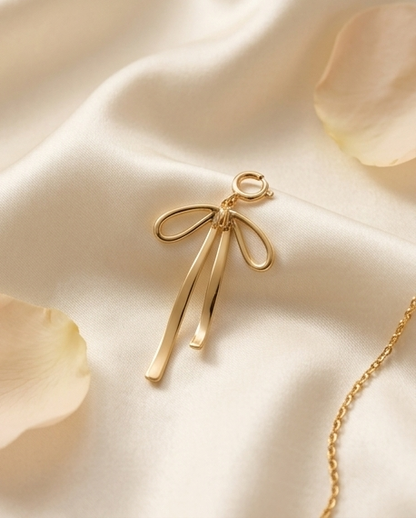 Gold filled ribbon bow convertible charm on silk fabric beside gold chain — Stacked by Jayneebell