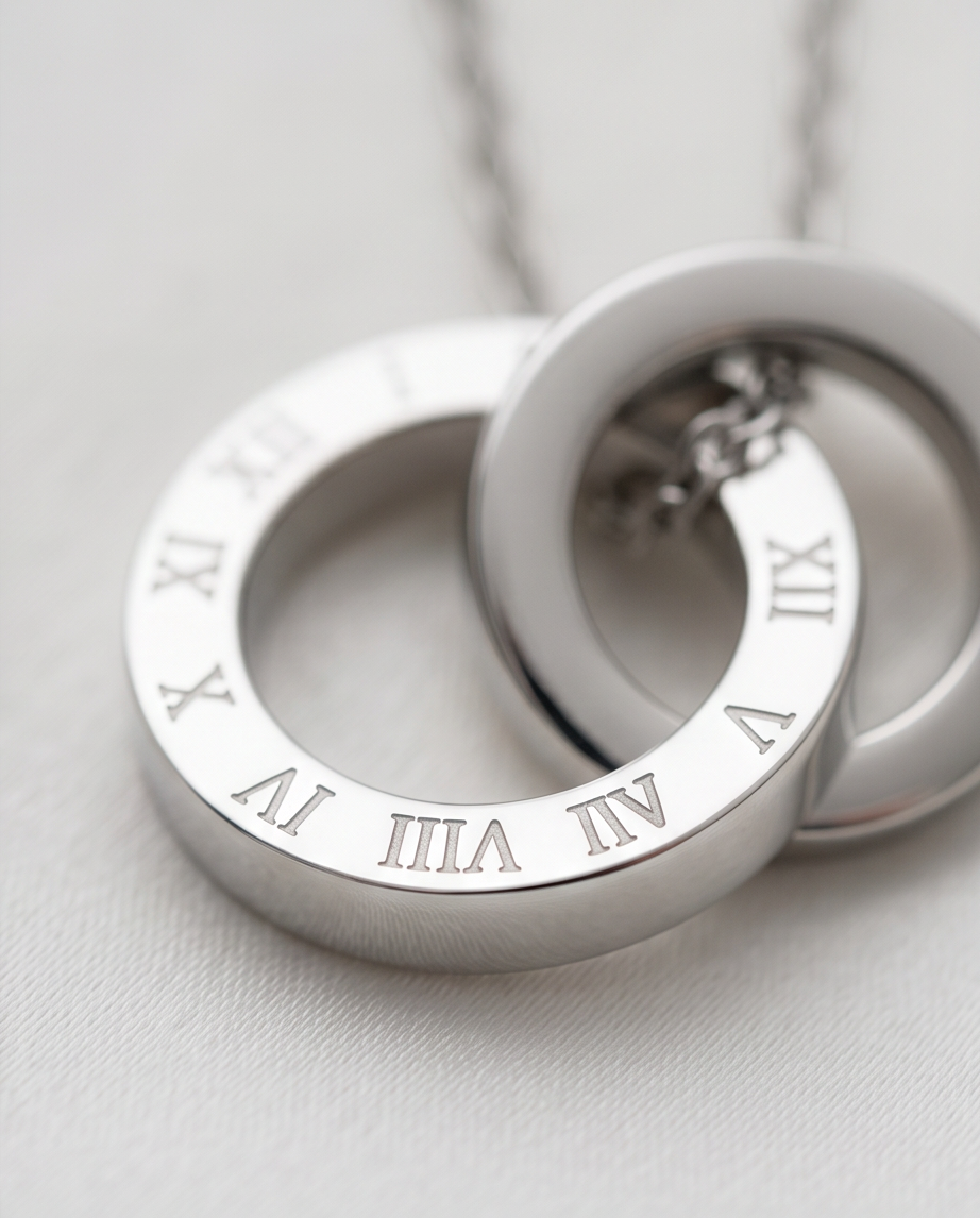 Close-up detail of The Roman double circle pendant with Roman numeral engraving, 18k PVD surgical steel, Stacked by Jayneebell