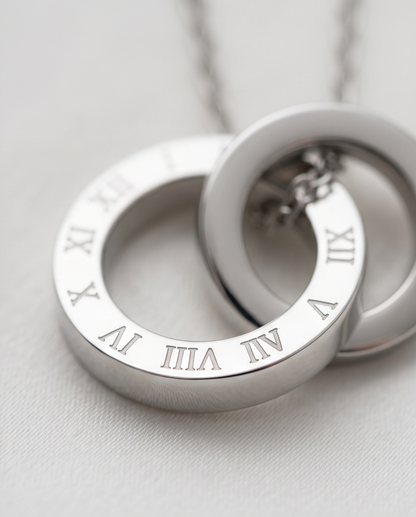 Close-up detail of The Roman double circle pendant with Roman numeral engraving, 18k PVD surgical steel, Stacked by Jayneebell