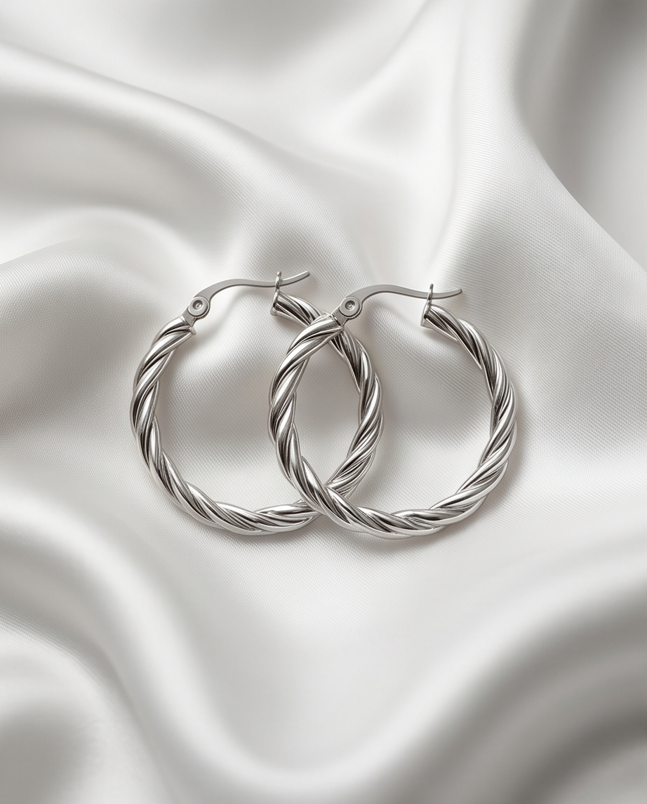 The Rope chunky twisted PVD hoop earrings in silver on white satin fabric, Stacked by Jayneebell