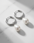 The Oyster genuine freshwater pearl drop silver PVD huggie hoop earrings on marble, Stacked by Jayneebell