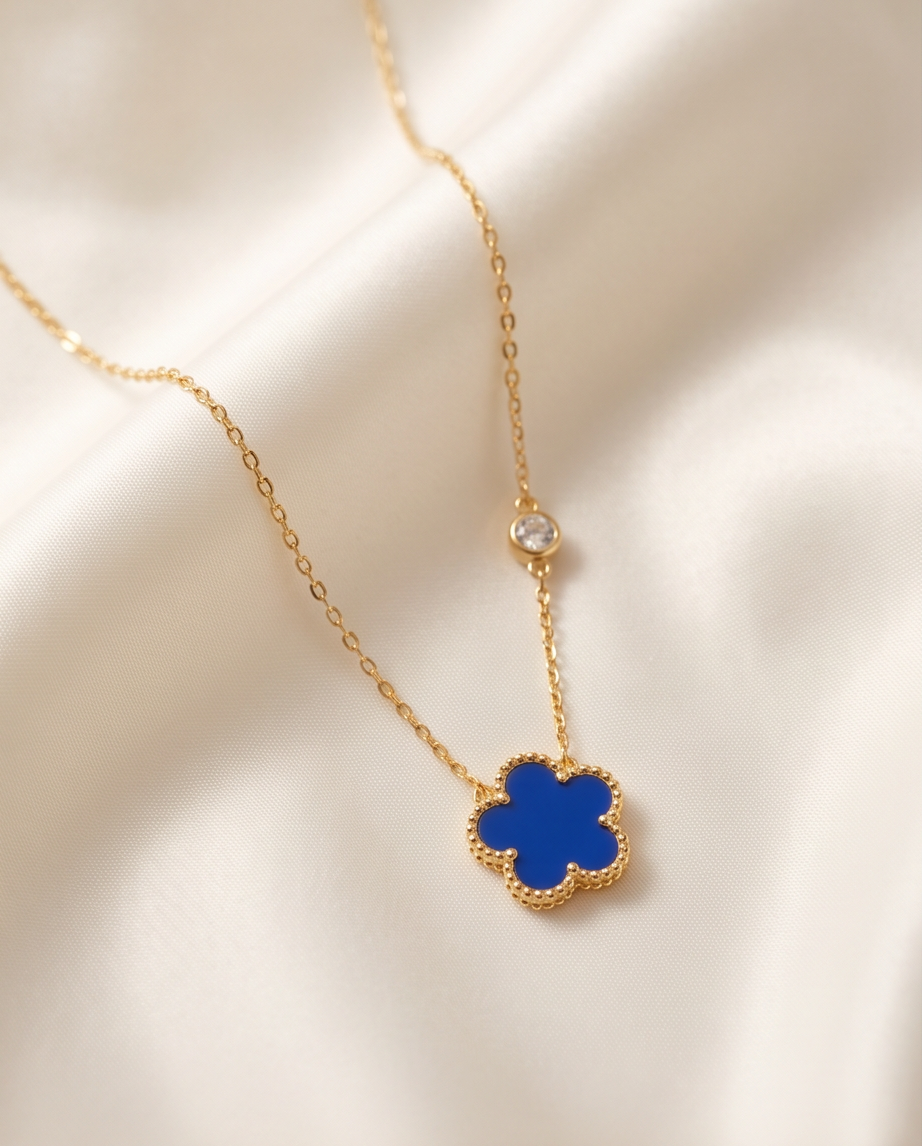 Très Clove cobalt blue enamel flower pendant gold PVD necklace on cream fabric, Stacked by Jayneebell