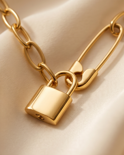 Close-up detail of Locked In gold PVD padlock pendant on paperclip chain, Stacked by Jayneebell