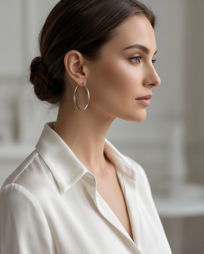 Model wearing The Silver Standard silver tube hoop earrings with white silk shirt, Stacked by Jayneebell