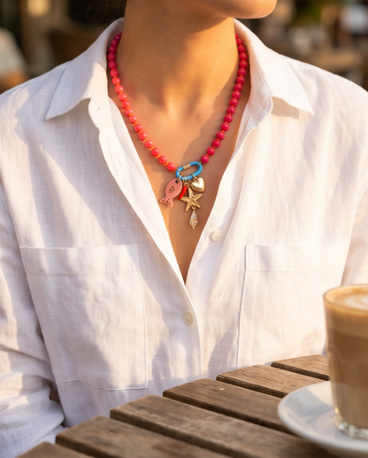 Model wearing The Catch coral beaded charm necklace with white shirt, Stacked by Jayneebell