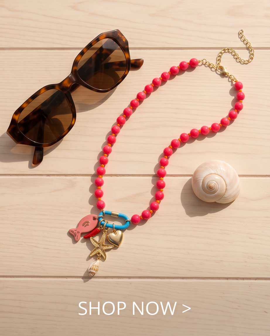 The Catch coral necklace flat lay with sunglasses on wood surface, Stacked by Jayneebell
