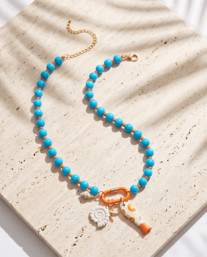 The Catch tide colorway blue beaded charm necklace with orange carabiner on stone, Stacked by Jayneebell