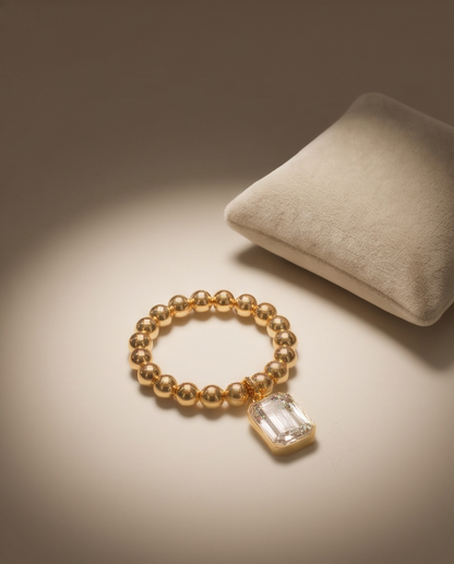 The Heirloom stretch ring with emerald-cut moissanite charm on a jewelry pillow | Stacked by Jayneebell