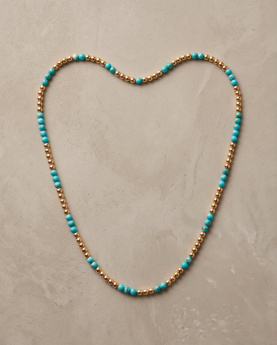 The Sedona Necklace laid in a heart shape, genuine turquoise and 14k gold filled 4mm beaded stretch necklace | Stacked by Jayneebell