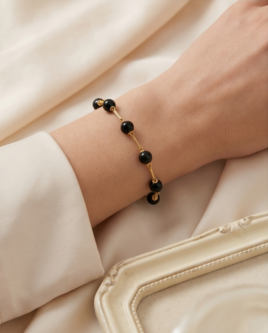 Black opal gold filled station bracelet styled on wrist — Stacked by Jayneebell