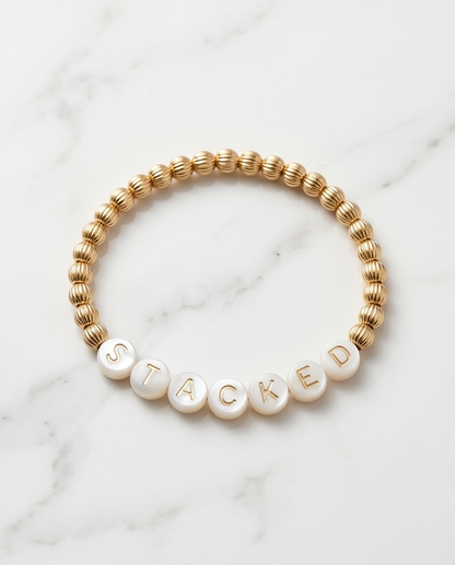 Mother of pearl letter bracelet with gold ribbed beads on marble — Just Sayin&