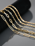 Gold chain necklaces on a dark surface
